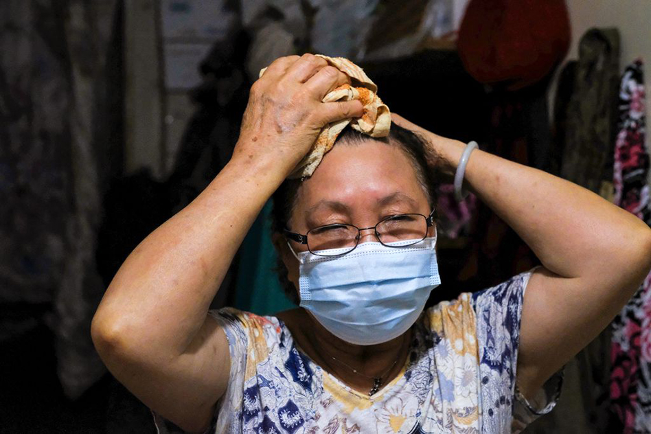 Laiying Yan, 73, attempted to cool off with a towel soaked in ice water in her tiny room on the fifth floor of a walkup in Boston’s Chinatown neighborhood after working during the day at a suburban restaurant.BARRY CHIN/GLOBE STAFF Strzepek_Globe_WEB.jpg