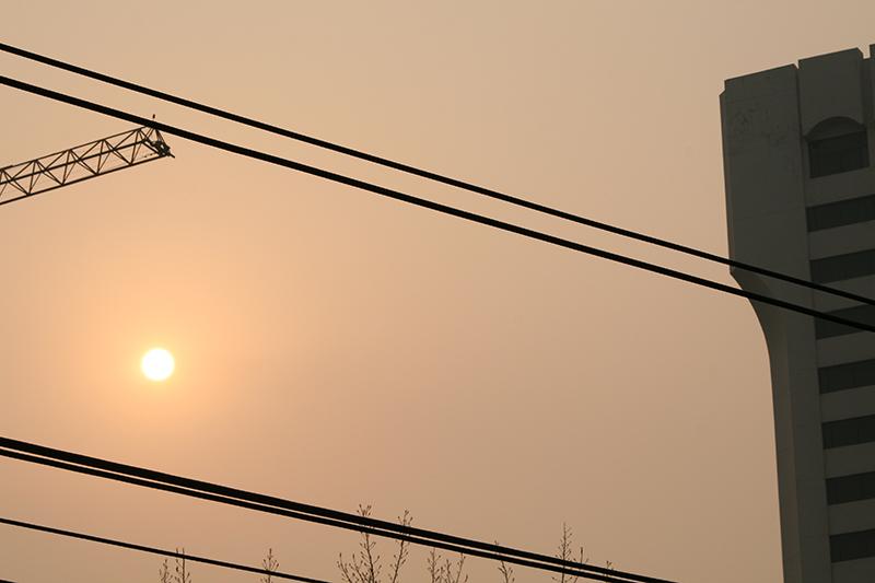 Beijing, China - Sun and smog in a hazy orange-brown sky.